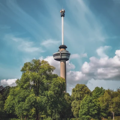 De Euromast in Rotterdam boven groene bomen en een grasveld